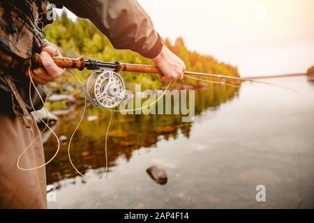 Pêcheur utilisant la pêche à la mouche dans la rivière de montagne Banque D'Images