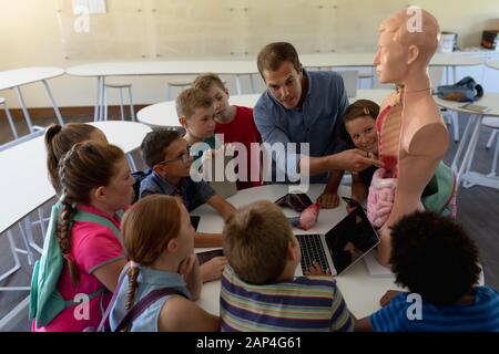 Professeur masculin utilisant un modèle d'anatomie humaine pour enseigner Banque D'Images