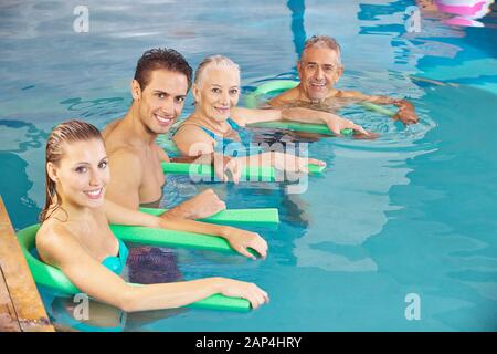 Happy group avec des nouilles à l'aquaforme natation en piscine Banque D'Images