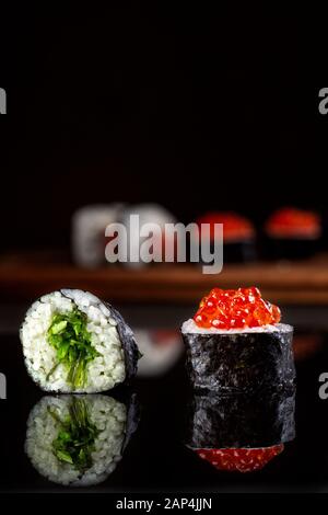 Jeu de rouleaux de sushi sur fond noir. Banque D'Images
