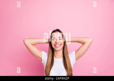 Photo de belle dame calme harmonique humeur tenant les bras derrière les yeux de la tête fermé toothy dreamy sourire porter décontracté blanc t-shirt isolé rose Banque D'Images