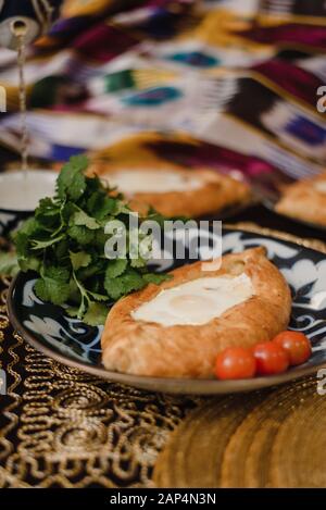 Adjara khachapuri sur la table. l'est dans d'oeufs frais pain chaud sur les plateaux orientaux est dans un restaurant. Banque D'Images