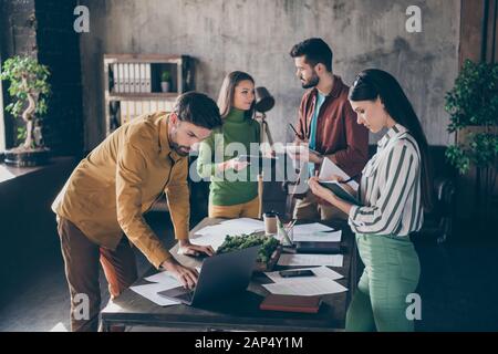 Compagnie de quatre bons gestionnaires de finances de cadres commerciaux et focalisés et attrayants préparer le plan de stratégie de démarrage de l'innovation au loft industriel Banque D'Images