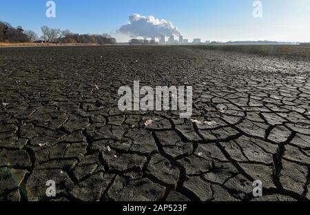 21 janvier 2020, le Brandebourg, Jänschwalde-Dorf : la vapeur d'eau s'élève de ses tours de refroidissement de la centrale thermique au lignite de Jänschwalde power plant de Lausitz Energie Bergbau AG (LEAG), alors que dans le premier plan l'éventrer fond d'un étang à poissons drainés peut être vu. Le gouvernement fédéral a un calendrier pour l'élimination de la lignite, avec les dates limites pour l'Jänschwalde et Schwarze Pumpe (les deux Spree-Neisse), a été reçu de manière différente dans la région de Lausitz Brandebourg. Conformément aux plans, la lignite Jänschwalde power plant doit être arrêté entre 2025 et 2028. Deux blocs ont un Banque D'Images