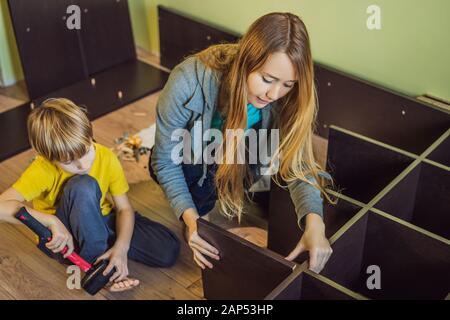 Mère et fils assemblant des meubles. Garçon aidant sa mère à la maison. Concept de famille heureuse Banque D'Images