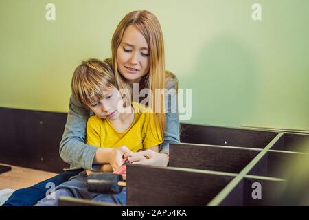 Mère et fils assemblant des meubles. Garçon aidant sa mère à la maison. Concept de famille heureuse Banque D'Images