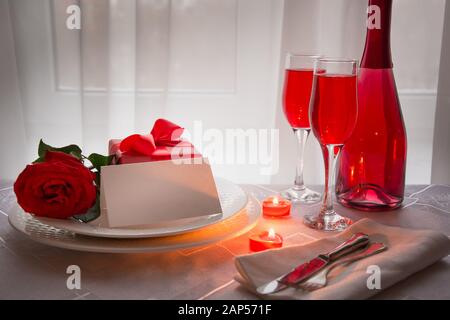 Dîner festif avec rose rouge et vin mousseux. Invitation romantique. Saint Valentin. Table réservée. Banque D'Images