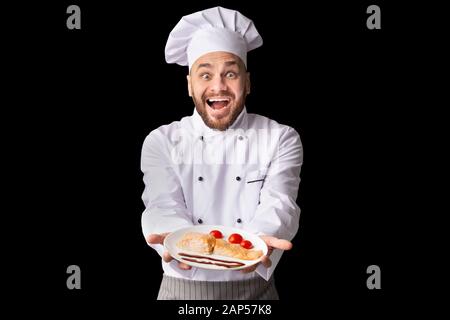 Chef Excité Montrant Plat Servant La Pose De Plat De Poisson, Studio Shot Banque D'Images