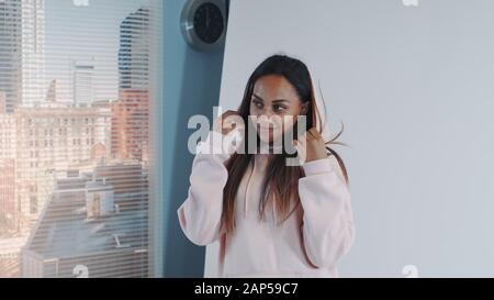 Gros plan sur un modèle africain heureux souriant et posant pour un photographe. Il y a des gratte-ciel en arrière-plan. Banque D'Images