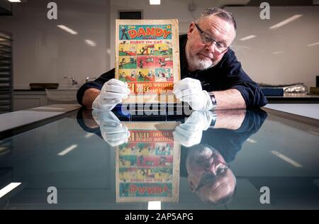 Restaurateur expositions Gordon Yeoman se penche sur une très rare première édition de la bande dessinée de Dandy, 4 décembre 1937, à la Bibliothèque nationale d'Écosse, Édimbourg. Banque D'Images