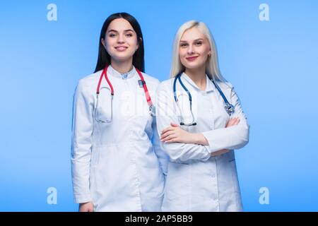 Une équipe de jeunes résidents. Médecin, infirmière et chirurgien en bleu. Un groupe d'étudiants en médecine de différentes nationalités regarde dans le cel Banque D'Images