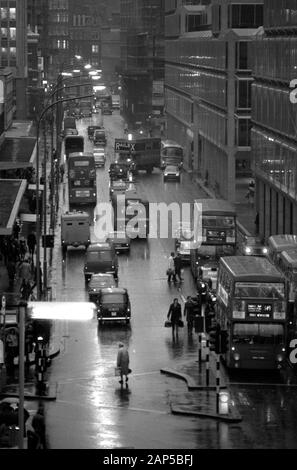 Londres 1970 Victoria Street. Les heures de pointe en soirée, les gens, les taxis, les voitures et les bus sont sombres et humides tandis que les navetteurs font leur chemin à la maison. 1976 ROYAUME-UNI HOMER SYKES Banque D'Images