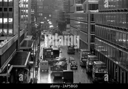 Londres 1970 Victoria Street. Les heures de pointe en soirée, les gens, les taxis, les voitures et les bus sont sombres et humides tandis que les navetteurs font leur chemin à la maison. 1976 ROYAUME-UNI HOMER SYKES Banque D'Images