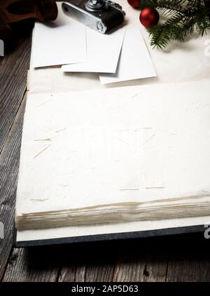 Ancien album photo, photos, appareil photo et branche de pin avec décorations de Noël sur fond en bois. Banque D'Images