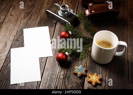 Vieilles photos, appareil photo, branche de pin et tasse de café avec décorations de noël sur fond en bois. Banque D'Images