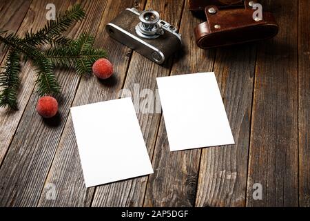 Vieilles photos, appareil photo et branche de pin avec décorations de noël sur fond en bois. Banque D'Images