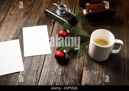 Vieilles photos, appareil photo, branche de pin et tasse de café avec décorations de noël sur fond en bois. Banque D'Images