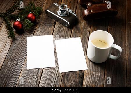 Vieilles photos, appareil photo, branche de pin et tasse de café avec décorations de noël sur fond en bois. Banque D'Images