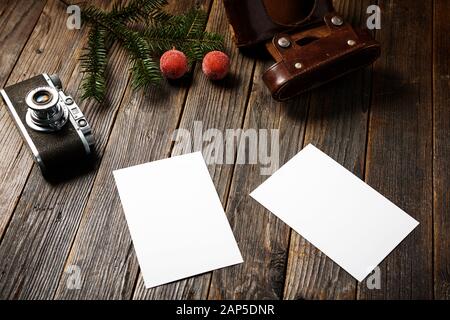 Vieilles photos, appareil photo et branche de pin avec décorations de noël sur fond en bois. Banque D'Images