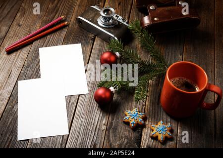 Vieilles photos, appareil photo, branche de pin et tasse de café avec décorations de noël sur fond en bois. Banque D'Images