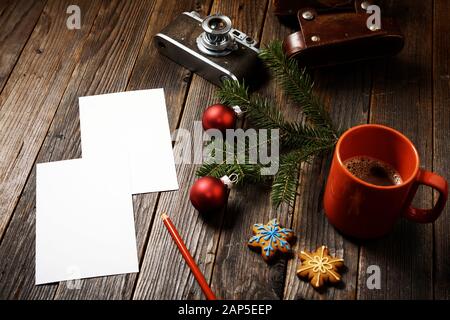 Vieilles photos, appareil photo, branche de pin et tasse de café avec décorations de noël sur fond en bois. Banque D'Images