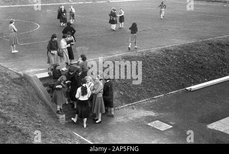 Années 60, historique, dans une école secondaire, un groupe de écolières se réunissent en dehors des marches d'une aire de jeux de tarmac nouvellement construite, Angleterre, Royaume-Uni. Banque D'Images