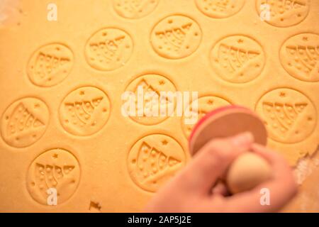 Pâte d'épices pour les biscuits de Noël et cookie stamp dans la main de femme. Timbre sur le thème de l'arbre de Noël, Noël nice texture de la pâte. Banque D'Images