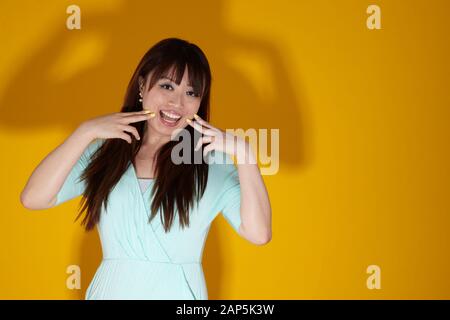 portrait amusant de femme asiatique sur fond jaune Banque D'Images