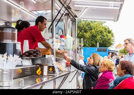 La vente de churros de carnavaliers à la Fiesta de San Sebastian van un fast-food à La Caleta, Costa Adeje, Tenerife, Canaries. Banque D'Images