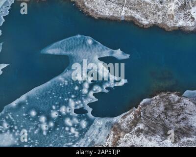 Vue aérienne des glaces. Vol au-dessus du lac gelé brisant la glace dans le lac rural. Photos de haute vue pendant la saison d'hiver. Banque D'Images