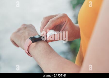 Femme à l'aide de bracelets à puce randonneur de trekking dans la nature. Close up of female hands avec montre sport, selective focus. Banque D'Images
