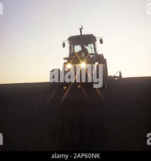 Chaume de céréales de labour avec tracteur John Deere au crépuscule sur une froide soirée givrée, Hampshire, Novembre Banque D'Images