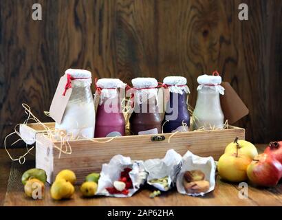 Smoothies colorés sur les bouteilles. Boisson colorée, shake de lait en bouteille avec des légumes frais et des humeurs sur fond de bois. Sain, propre Banque D'Images