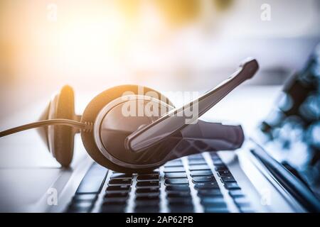 Support de communication, centre d'appels et customer service help desk. Casque VOIP sur ordinateur portable Clavier d'ordinateur. Banque D'Images