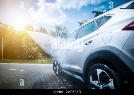 Lave-auto manuel avec de l'eau sous pression en lavage de voiture à l'extérieur. Banque D'Images