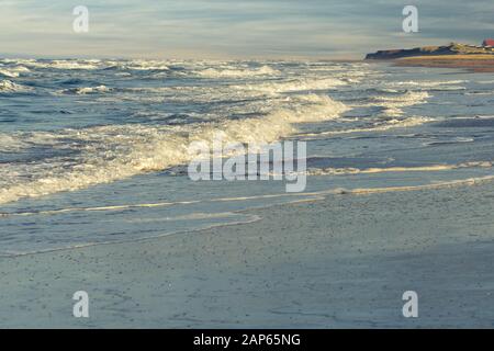 Les rouleaux en surf sur une plage de sable sur la rive nord de l'Île du Prince Édouard, Canada. Banque D'Images