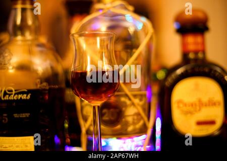 Viersen, Allemagne - 15 Novembre. 2019 : gros plan de verre isolé pour la dégustation de rhum. Fond de bouteilles floues. Banque D'Images