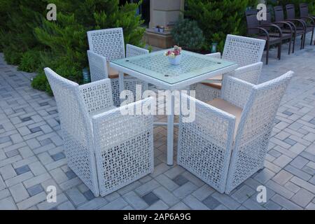 Chaises et tables d'un restaurant avec parasols.terrasse jardin table blanche pour un délicieux brunch. Table et chaises en plastique blanc Banque D'Images