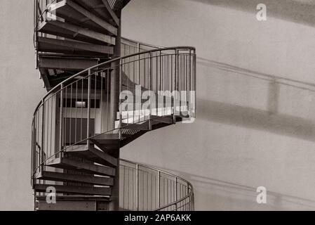 Un escalier en spirale en détail, qui jette une belle ombre sur le mur de la maison, escalier en spirale, ombre, extérieur, ombre longue Banque D'Images