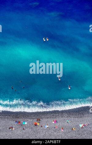 Plage tropicale avec des serviettes de plage colorées, des gens, des plongeurs et des surfeurs - vue aérienne de haut en bas Banque D'Images