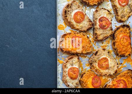 Fromage sur pain grillé. Tomate et fromage sur du pain au levain grillé sur une plaque de cuisson Banque D'Images
