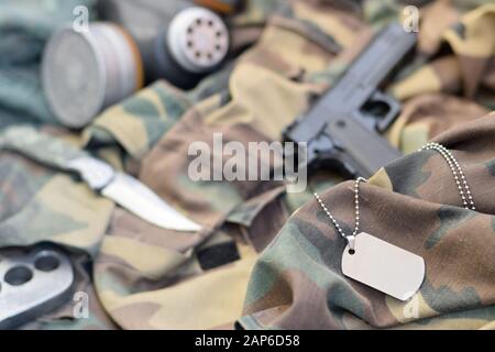 Les soldats stacker masque à gaz soviétique se trouve avec un pistolet et un couteau sur des vestes de camouflage kaki vertes. Étiquettes pour chien et porte-fusée en laiton. Post apocalypse survivre Banque D'Images