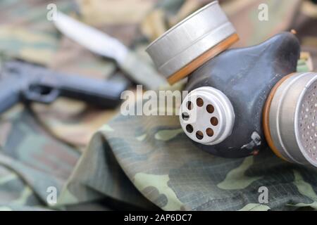 Les soldats stacker masque à gaz soviétique se trouve avec un pistolet et un couteau sur des vestes de camouflage kaki vertes. Kit post-apocalypse Surviving items Banque D'Images