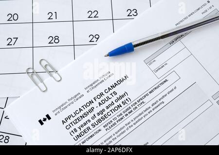 La demande de citoyenneté canadienne pour les adultes et le stylo bleu se trouve sur la page du calendrier Banque D'Images