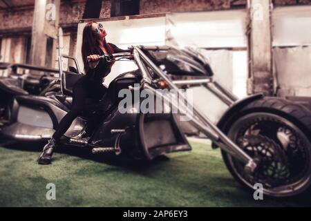 modèle féminin à côté de sa nouvelle moto. Banque D'Images