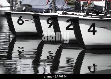 Quatre bateaux à voile blancs sur une rangée dans un port Banque D'Images