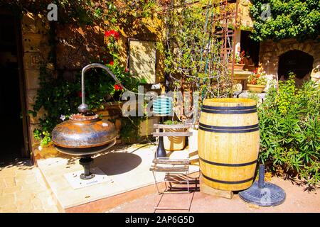 Roussillon En Provence, France - 2 Octobre. 2019: Vue sur la maison méditerranéenne d'ocre rouge avec la vigne grimpant la façade, tonneau de vin, chaise pliant en bois Banque D'Images