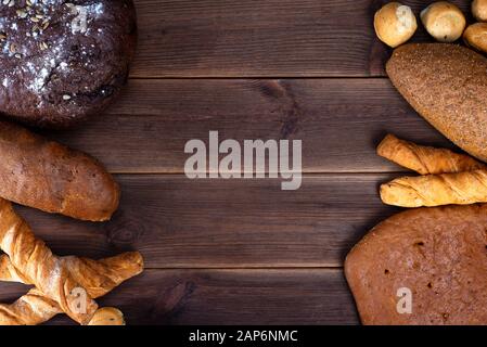 Des plats de boulangerie frais, des pains rustiques croquants et des muffins sur une table en bois. Vue de dessus et espace de copie pour le texte Banque D'Images