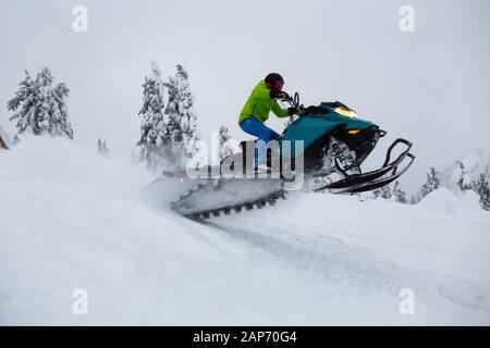 Homme aventureux une Motoneige Équitation dans blanche neige Banque D'Images