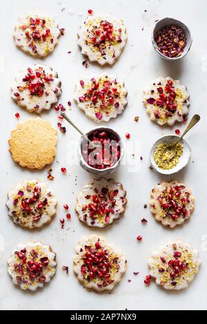 Sugar Cookies sans gluten avec glaçure sans oeufs décorés de graines de grenade, des pétales de rose et à la pistache Banque D'Images